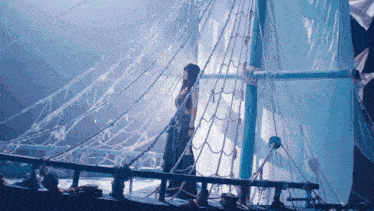 a woman in a long dress is standing on the deck of a boat