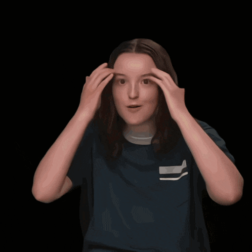 a girl wearing a blue shirt with a white stripe on the left shoulder