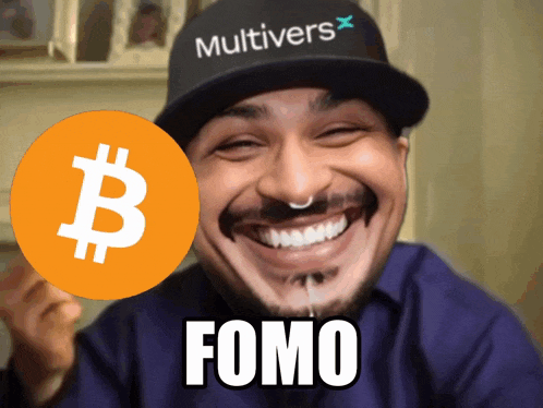 a man wearing a hat that says multivers holds up a bitcoin sign
