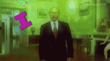 a man in a suit and tie stands in a room with a purple arrow pointing to the number 1