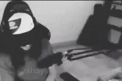 a black and white photo of a person wearing a helmet in a room .