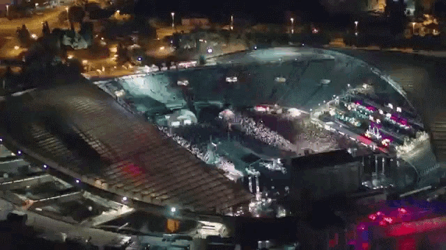 an aerial view of a stadium at night with lots of lights