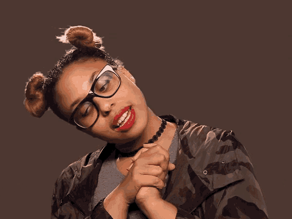 a woman wearing glasses and a choker is making a middle finger gesture