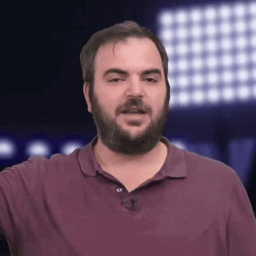 a man with a beard wears a purple shirt