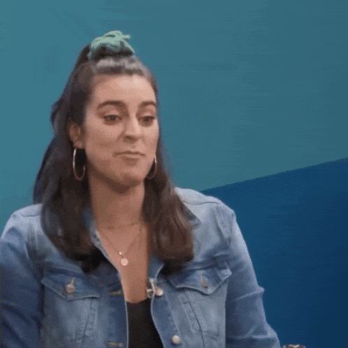 a woman in a denim jacket is making a funny face with the word not above her