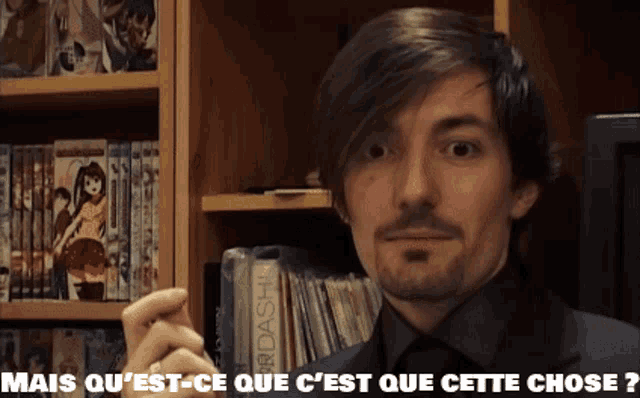 a man standing in front of a bookshelf with the words mais qu 'est-ce que c ' est que cette chose
