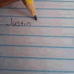 a person writes the name justin bie on a piece of paper