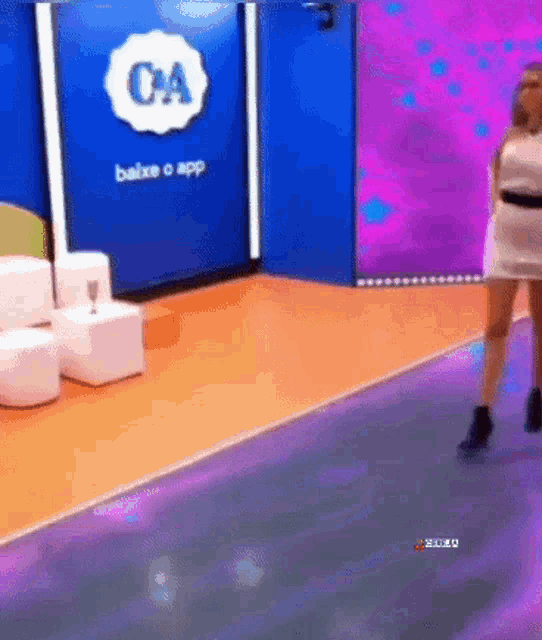 a woman is dancing in front of a sign that says ca