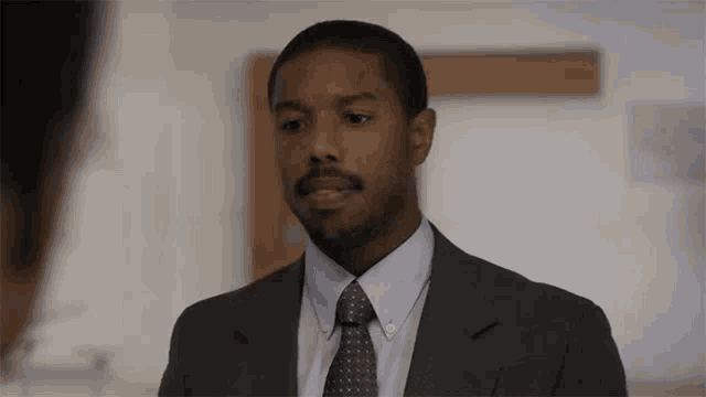 a man in a suit and tie is talking to someone