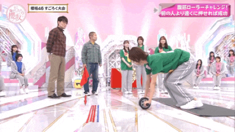 a woman in a green shirt rolls an exercise ball on a stage