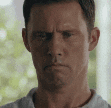 a man in a white shirt is making a funny face .
