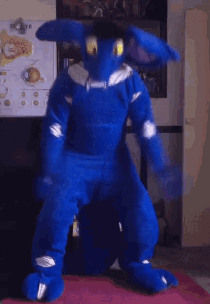 a person in a blue bunny costume is standing on a red mat