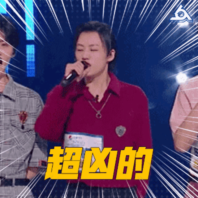 a woman singing into a microphone with chinese writing on the bottom right