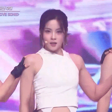 a woman in a white tank top is dancing on a stage