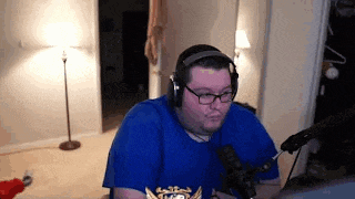 a man wearing glasses and headphones is sitting in front of a microphone .