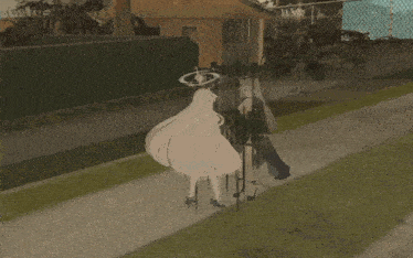 a woman in a white dress is walking down the sidewalk