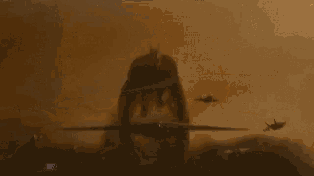 a group of fighter jets are flying in the sky above a monster .