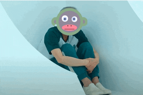 a man with a monkey mask on his face sits on the floor
