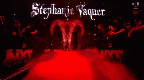 a woman in a devil costume is surrounded by smoke and a sign that says w live
