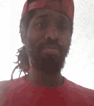 a man with a beard is wearing a red hat and a red shirt