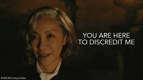 a woman in a dark room with the words you are here to discredit me