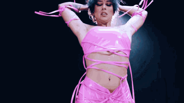 a woman in a pink top and skirt is tied up