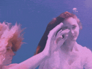 a woman in a white dress is under water