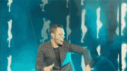 a man is flying through the air while holding a microphone in his hand .