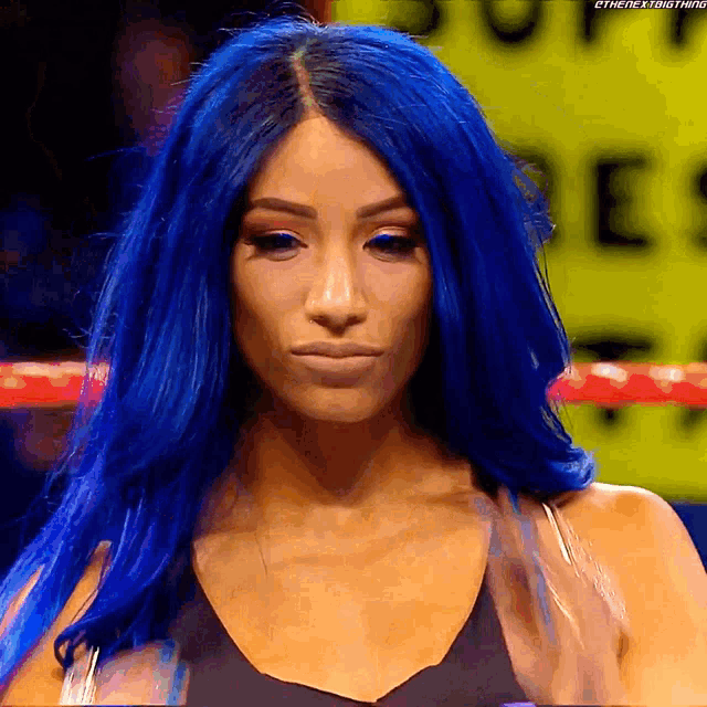 a woman with blue hair is standing in a ring