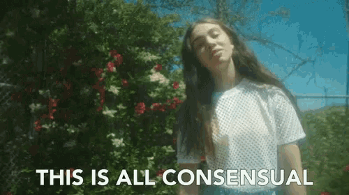 a woman is standing in front of a bush with the words this is all consentual behind her