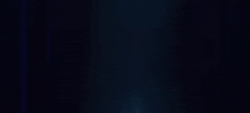 a blurry picture of a man holding a feather in his hand in the dark .