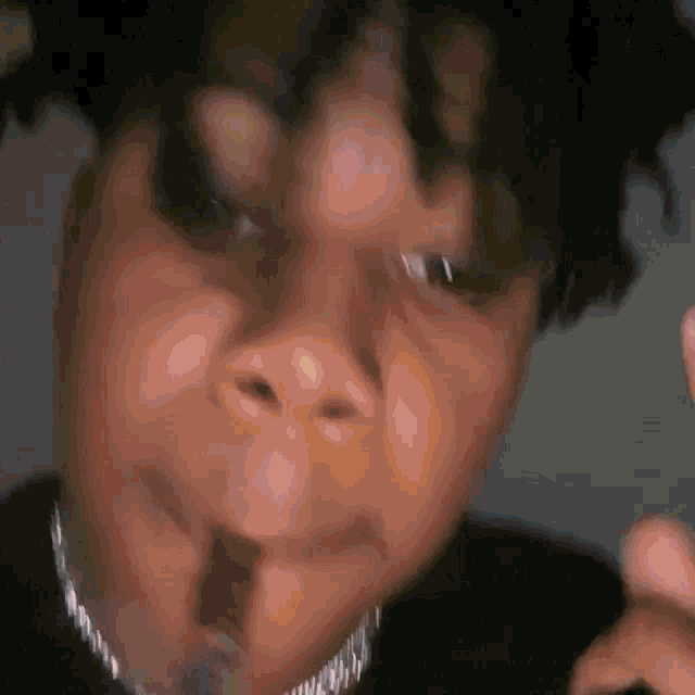 a close up of a person 's face with a microphone in his mouth .
