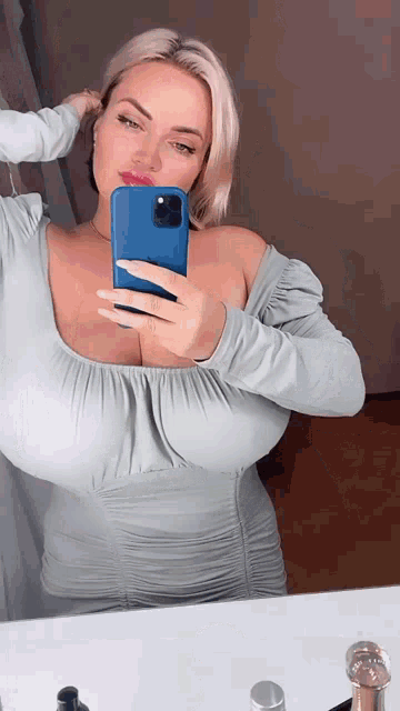 a woman is taking a selfie with her phone in front of a mirror