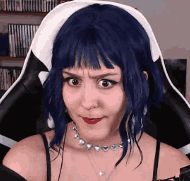 a woman with blue hair is wearing a choker and a black top