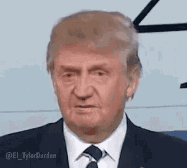 a close up of donald trump 's face in a suit