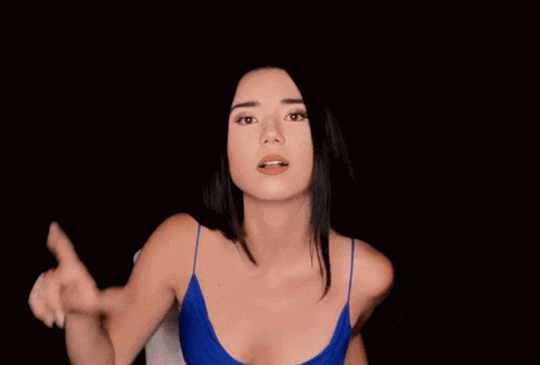 a woman in a blue tank top is pointing her finger