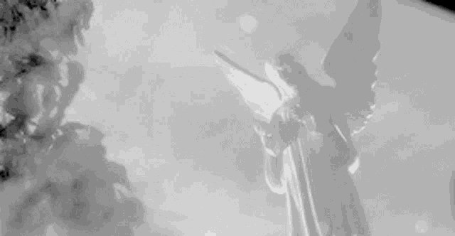 a black and white photo of a statue of an angel holding a cross .