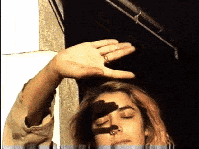a woman with a ring on her finger holds her hand over her head