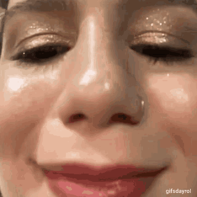 a close up of a woman 's face with a nose ring and lipstick .