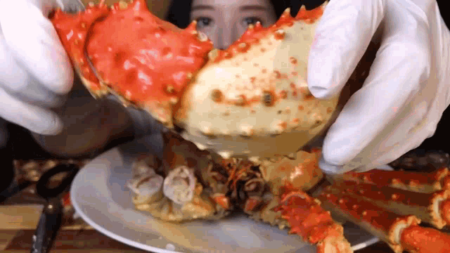 a woman is eating a king crab on a plate .