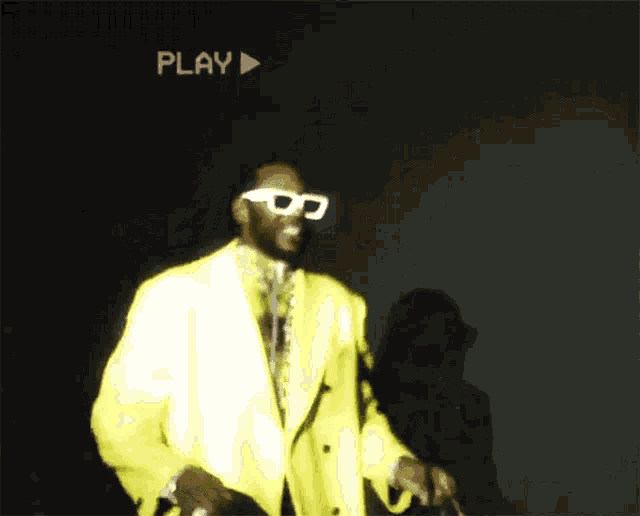 a person wearing a yellow jacket is dancing in the dark