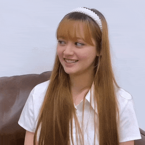 a girl wearing a headband with pearls on it