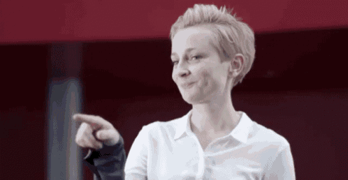 a woman in a white shirt is pointing her finger at something