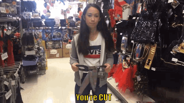 a girl in a levis shirt holds a pair of scissors in a store