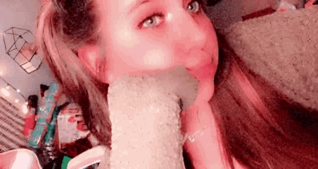 a young woman is taking a selfie with a stuffed animal in her mouth .