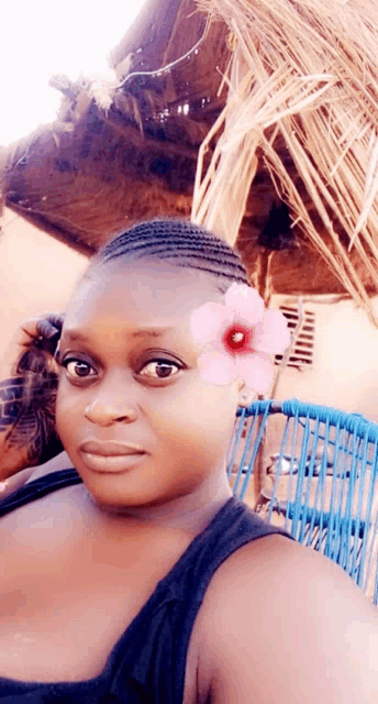 a woman wearing a braided hairstyle has a flower in her hair
