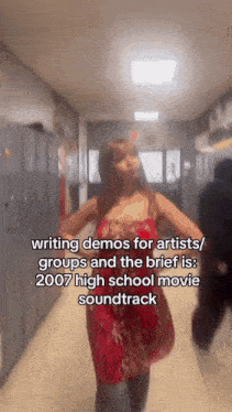 a woman in a red dress is dancing in a hallway while talking about writing demos for artists / groups