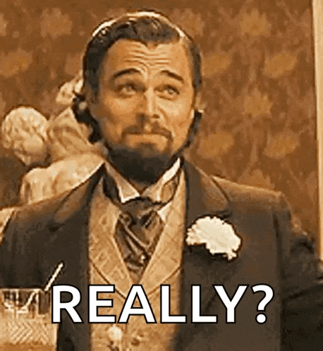 a man with a beard is wearing a suit and tie and making a funny face .