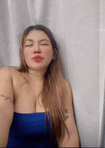 a woman with her eyes closed has a tattoo on her arm that says ' a '