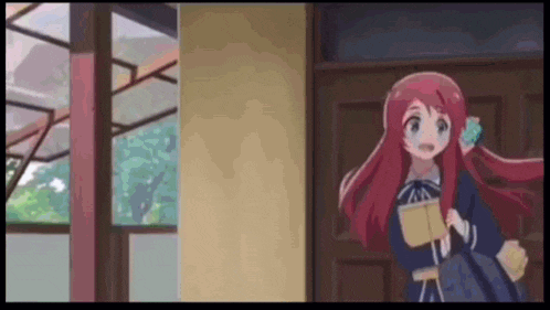 a girl with long red hair is standing in front of a door .